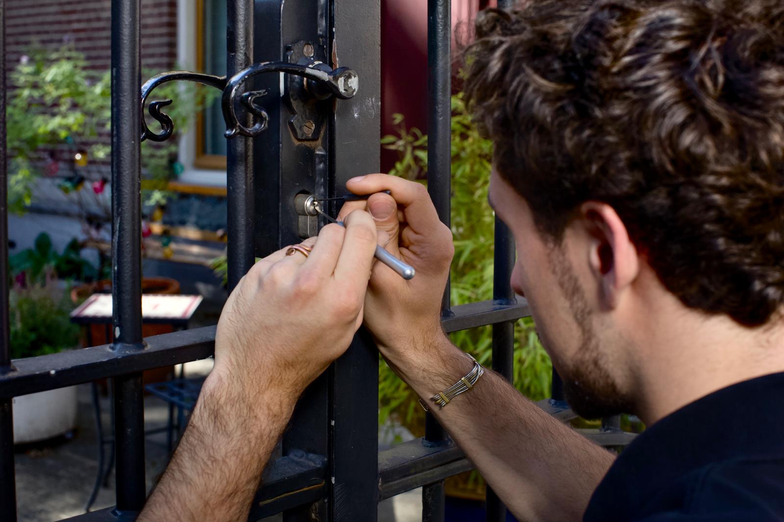 Slotenmaker opent het slot van een smeedijzeren poort in Amsterdam zonder schade